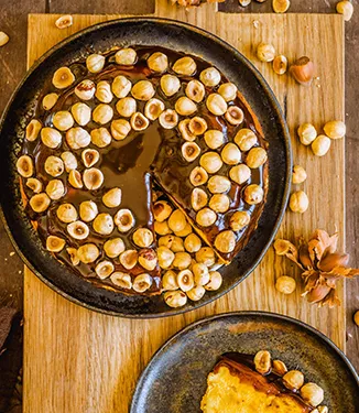 Kurpitsajuustokakku karpaloiden, kinuskin ja hasselpähkinöiden kera