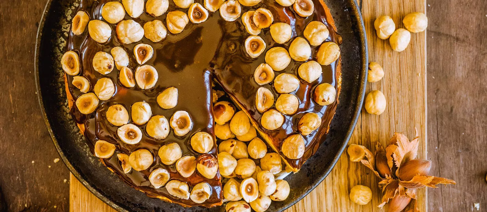 Kurpitsajuustokakku karpaloiden, kinuskin ja hasselpähkinöiden kera